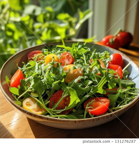 Experience freshness with this vibrant arugula and cherry tomato salad under warm sunlight 131276287