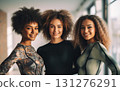 Three joyful women with fabulous afros radiate confidence and sisterhood in a sunlit room 131276291