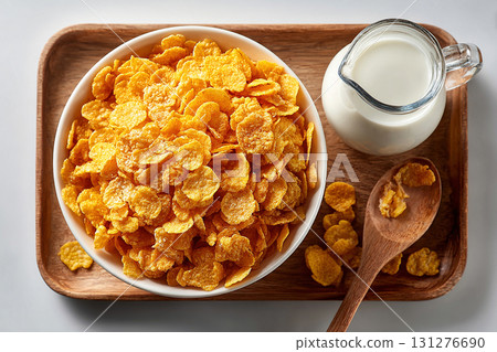 Viral food trend. Top view of a tray of cornflakes on a bowl and milk jug on a white background. Classic breakfast. 131276690
