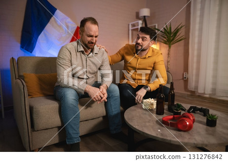 Two friends share a moment of support in a cozy living room, highlighting the importance of camaraderie during difficult times Two friends share a moment of support in a cozy living room, highlighting the importance of camaraderie during difficult times 131276842