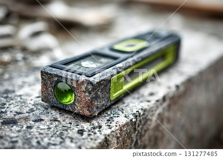 Green spirit level resting on concrete block at construction site Green spirit level resting on concrete block at construction site 131277485
