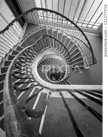 Spiral staircase viewed from above creates dramatic black and white architectural composition Spiral staircase viewed from above creates dramatic black and white architectural composition 131277558