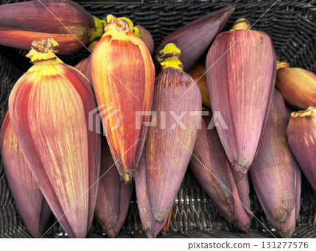 Close-up of fresh banana blossoms in a market basket. Exotic edible flowers used in Southeast Asian cuisine. 131277576