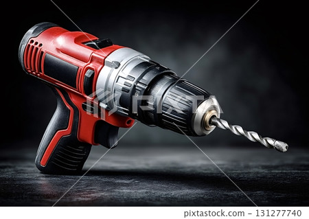 Red and black cordless drill resting on dark background 131277740