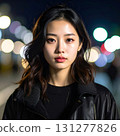 A portrait of a woman taken in the city at night. Her face illuminated by the light creates a cool, urban atmosphere. 131277826