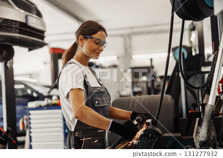 A Skilled Female Mechanic Works at an Auto Repair Shop, Engaging in Various Tasks A Skilled Female Mechanic Works at an Auto Repair Shop, Engaging in Various Tasks 131277932