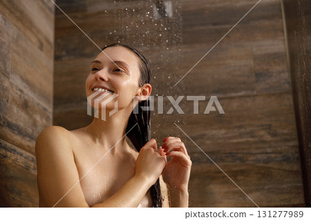 A Smiling Woman Indulging in a Refreshingly Relaxing Shower Experience of Pure Joy 131277989