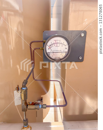 Pressure gauge on a piping system at a commercial facility during daylight 131278065