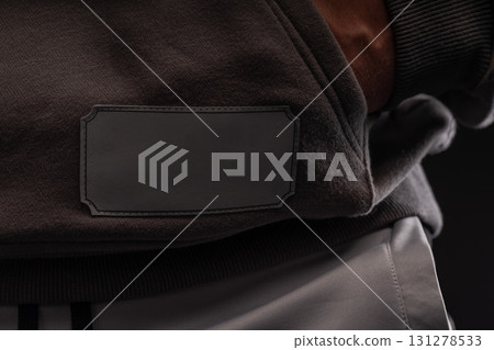 athletic man wearing a gray hoodie stands confidently in a stylish indoor environment. He appears focused and ready for an active workout session amid a sleek background. 131278533