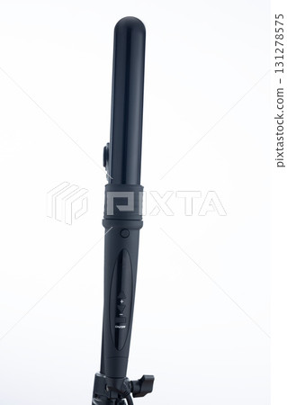 curling iron is displayed highlighting its sleek black design and buttons for temperature control. Ideal for creating beautiful curls this tool is must have for hairstyling enthusiasts. 131278575