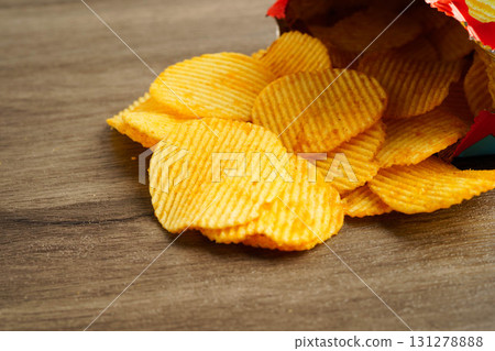 Potato chips in open bag, delicious BBQ seasoning spicy for crips, thin slice deep fried snack fast food. Potato chips in open bag, delicious BBQ seasoning spicy for crips, thin slice deep fried snack fast food. 131278888