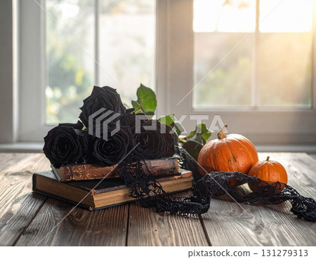 A gothic display of black roses, books, and pumpkins in bright light 131279313