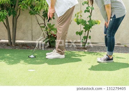 Couple enjoying putting golf (leisure, vacation) 131279405