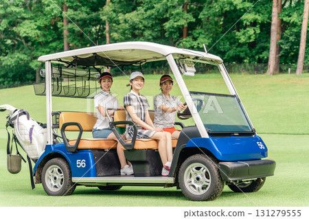 A golfer woman riding a golf cart on a golf course (golf girl) A golfer woman riding a golf cart on a golf course (golf girl) 131279555