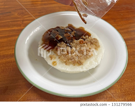 Pour the soy sauce paste from the plastic bag into the rice cake 131279566