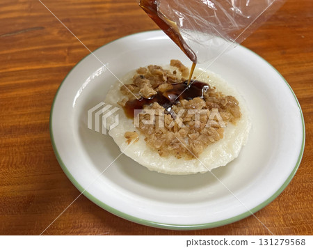 將醬油膏從塑膠袋裡倒入碗粿中 131279568