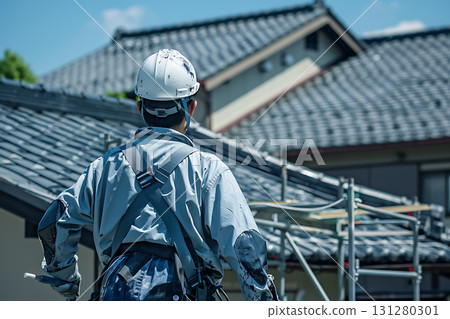Rear view of a Japanese construction worker working on a tiled roof Rear view of a Japanese construction worker working on a tiled roof 131280301
