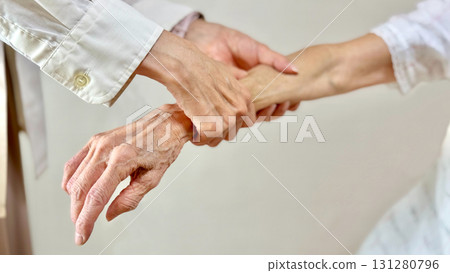 Woman's hands massaging an elderly woman's arm Woman's hands massaging an elderly woman's arm 131280796