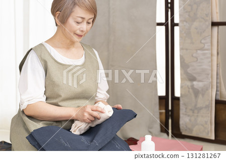 Senior woman caring for and arranging her kimono Senior woman caring for and arranging her kimono 131281267