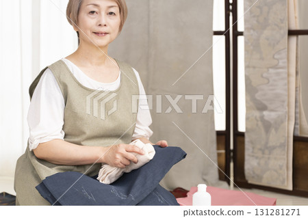 Senior woman caring for and arranging her kimono 131281271