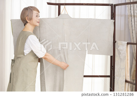 Senior woman caring for and arranging her kimono Senior woman caring for and arranging her kimono 131281286