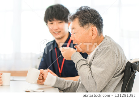 Senior man taking medicine at nursing home, male caregiver staff 131281385