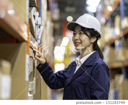 A woman in work clothes working in a factory A woman in work clothes working in a factory 131283749
