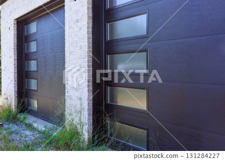 Dark garage doors feature glass panels stand build new house 131284227
