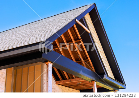 Roof structure of new house being built, highlighting wooden beams, shingles build new house 131284228