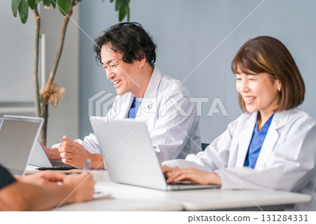 身穿白大褂的男女醫生坐在辦公桌前工作 身穿白大褂的男女醫生坐在辦公桌前工作 131284331