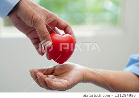 Asian elder senior woman patient holding red heart in hospital. Asian elder senior woman patient holding red heart in hospital. 131284986