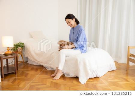 Pet: Dog relaxing on bed with owner 131285215