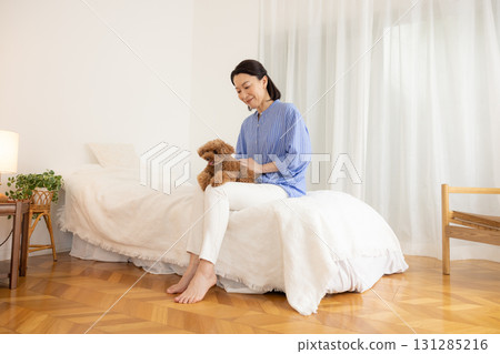 Pet: Dog relaxing on bed with owner Pet: Dog relaxing on bed with owner 131285216