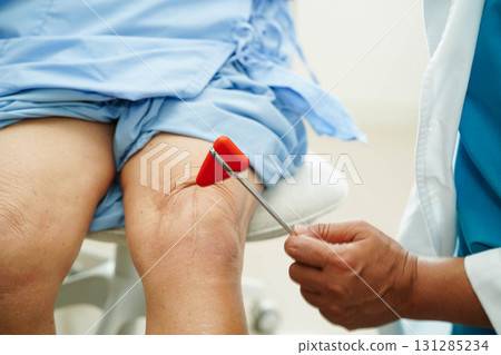Doctor checking Asian elderly woman patient with scar knee replacement surgery in hospital. 131285234
