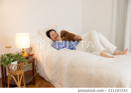 寵物：玩具貴賓犬與主人一起在床上休息 131285341