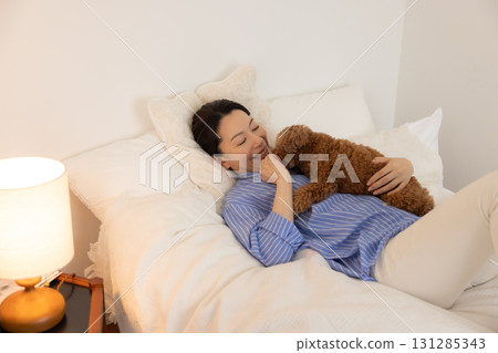 寵物：玩具貴賓犬與主人一起在床上休息 131285343