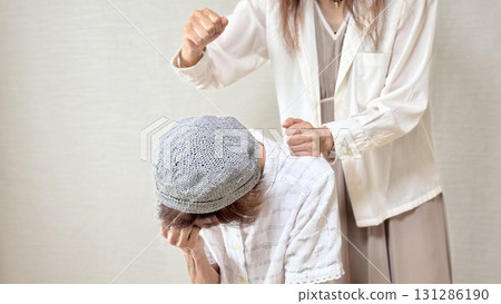 一名女子的手正要從後面擊打一名老年婦女 一名女子的手正要從後面擊打一名老年婦女 131286190