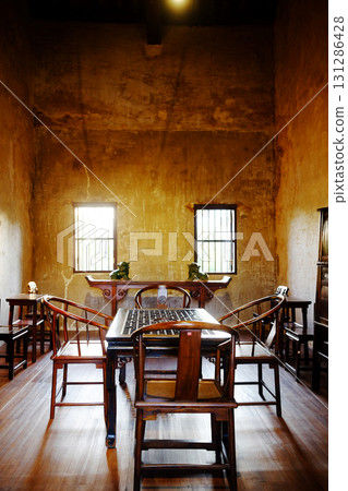 Antique old wooden table and chair furniture of Chinese style in vintage and rustic grunge concrete wall in living room with natural sunlight in Bangkok of Thailand. Vertical photo Antique old wooden table and chair furniture of Chinese style in vintage and rustic grunge concrete wall in living room with natural sunlight in Bangkok of Thailand. Vertical photo 131286428