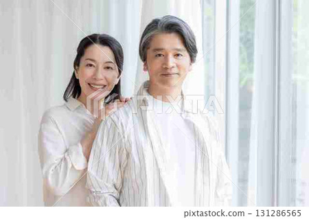 A middle-aged couple chatting by the window 131286565