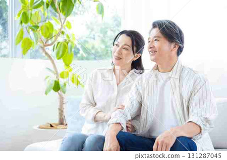 A middle-aged couple relaxing on the sofa 131287045
