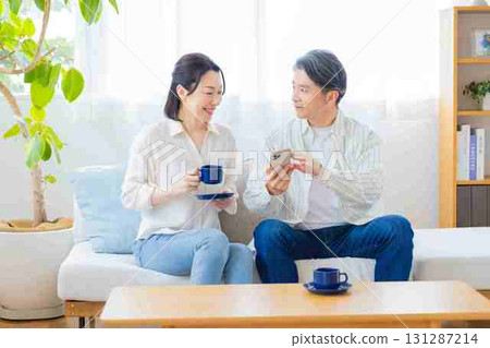 A middle-aged couple relaxing on the sofa A middle-aged couple relaxing on the sofa 131287214