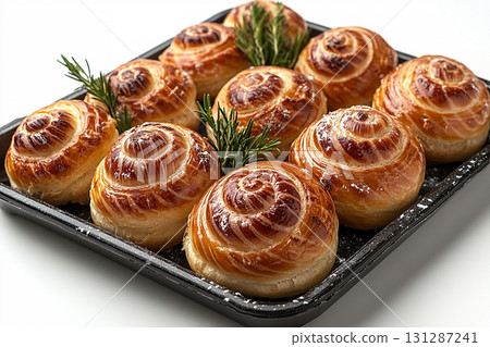 Romantic baked buns. Variety of baked snail-shaped buns in on a wooden trading tray on a white background. 131287241