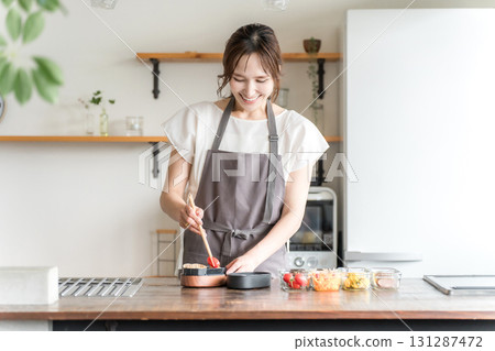 Young Asian woman (mother, wife, housewife) packing lunch in the kitchen Young Asian woman (mother, wife, housewife) packing lunch in the kitchen 131287472