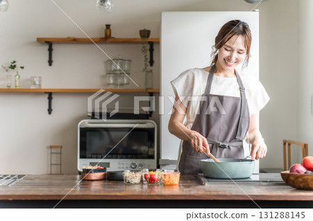 一位年輕的亞洲女性(母親、妻子、家庭主婦)在廚房裡做午餐盒 一位年輕的亞洲女性(母親、妻子、家庭主婦)在廚房裡做午餐盒 131288145