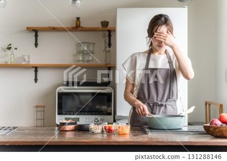 一位家庭主婦在廚房做午餐時遇到困難 131288146