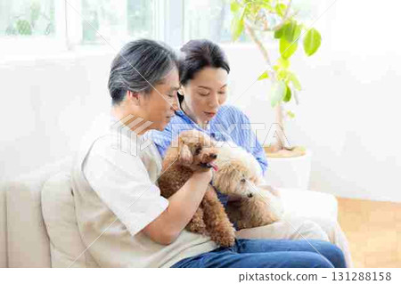 A middle-aged couple spending time with their dog in the living room A middle-aged couple spending time with their dog in the living room 131288158