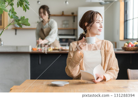 Woman reading while drinking coffee at a cafe Woman reading while drinking coffee at a cafe 131288394