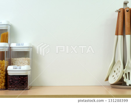 Empty wall for copy space on a wooden kitchen counter decorated with a set of ladles and containers for ingredients. Empty wall for copy space on a wooden kitchen counter decorated with a set of ladles and containers for ingredients. 131288399