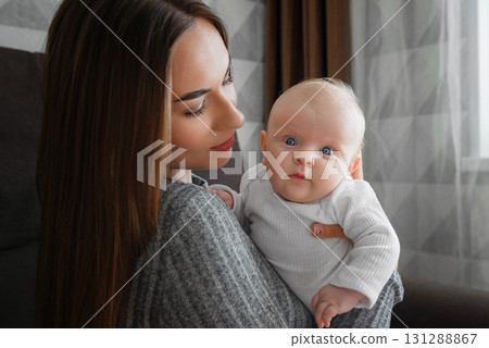 Mom holds a infant baby in her arms close-up. 131288867