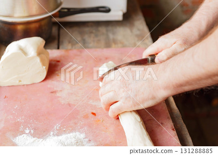 Cutting and rolling out raw dough for baking. Cutting and rolling out raw dough for baking. 131288885